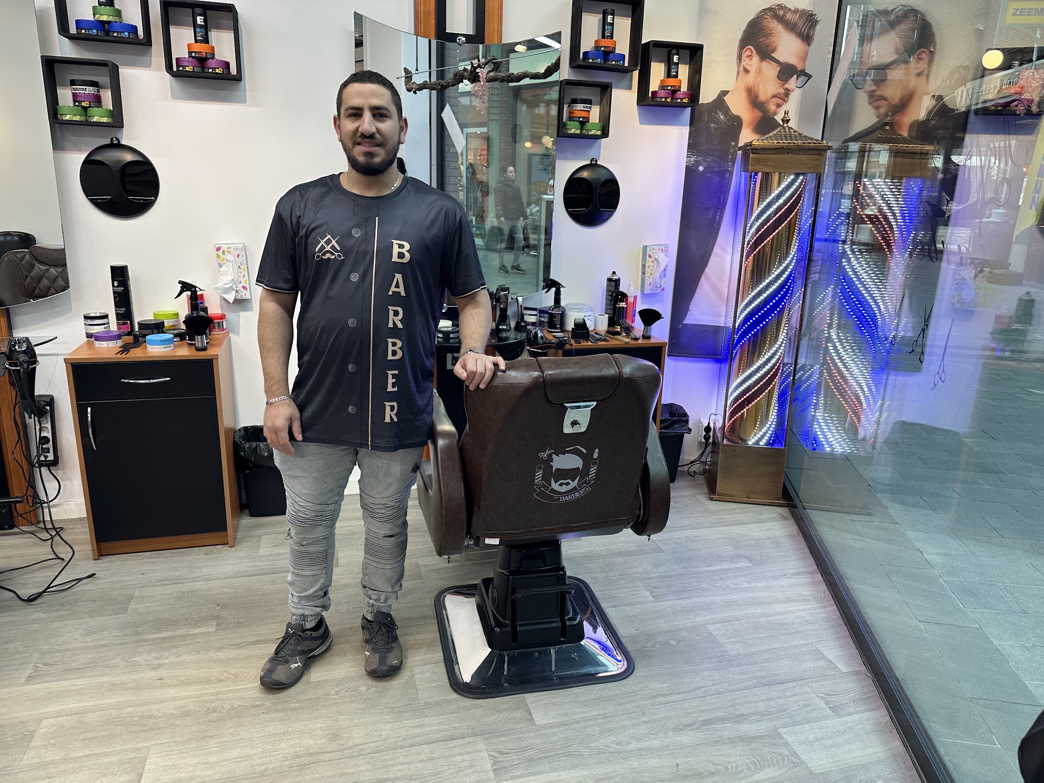 Ahmad van Royal Scissors naast de barberstoel in zijn zaak